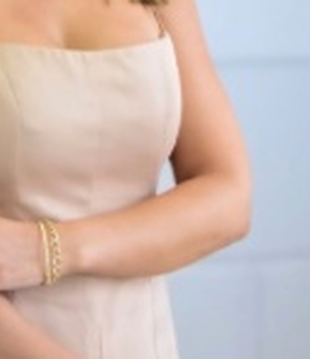 Detalhe de pulseira dourada no pulso, sem mostrar o rosto